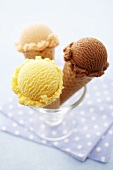 Three ice cream cones with different flavours of ice cream