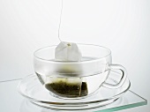 Hot water and tea bag in glass cup