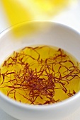 Saffron threads in a small bowl of water