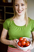 Young woman holding a bowl of tomatoes