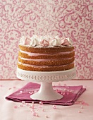 Layered raspberry cream cake on cake stand