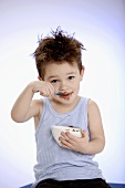 Small boy eating chocolate pudding