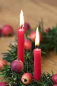 Christmas yew wreath with ornamental apples & two red candles
