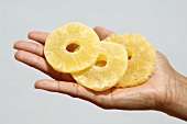 Hand holding dried pineapple slices