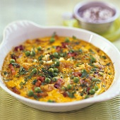Baked eggs with peas, shrimps and ham