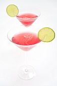 Two Cosmopolitan cocktails with slices of lime