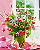 Tulips and ornamental cherry blossom in glass vase