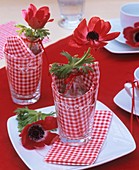 Red anemones in glasses (table decoration)
