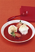 Poached meringues on strawberry sauce