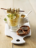 Sauerkraut in glass with slices of white sausage and salted pretzel