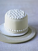 Small white cake decorated with icing