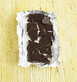Broken bar of chocolate on silver paper