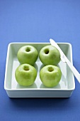 Four green apples, cored
