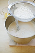 Sieving flour into cake mixture