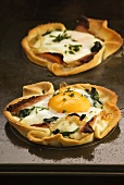 Mini-pizzas topped with fried egg and bacon