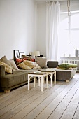 Sofa mit Kissen im Altbau-Wohnzimmer mit Dielenboden