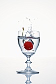 Cherry falling into a glass of cherry schnapps