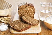 Wholemeal rye bread, partly sliced, coarse salt, flour and jug of water