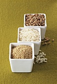 Bulgur wheat, rice and green spelt in small white bowls