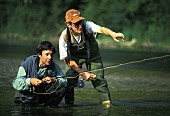 Zwei Männer beim Fliegenfischen im Fluss (Frankreich)