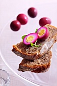 Quails' eggs marinated in beetroot juice on bread