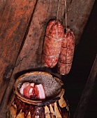 Preserving pork: bacon on sea salt and sausage hanging up to dry
