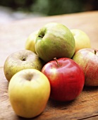Various apples on wooden table