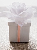 Box with ribbon and white flower