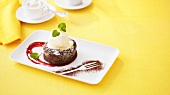 Warm chocolate pudding with ice cream and raspberry sauce