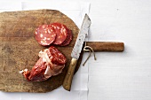 Chorizo with knife on wooden board