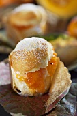 A muffin with Japanese persimmon and pumpkin jam on autumnal leaves