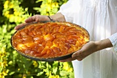 Woman holding apricot tart