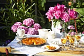 Apricot tart and peonies on garden table