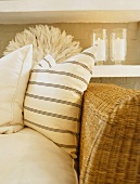 Pale scatter cushions against backrest of wicker sofa