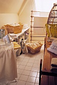 Attic laundry room with baskets of washing and an iron