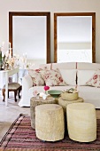 Rose-patterned scatter cushions on elegant sofa behind five tree stump tables