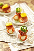 Mozzarella balls wrapped in ham with dried tomatoes and cucumber