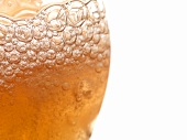 A glass of foamy cider (close-up)