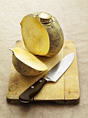 A sliced turnip on a chopping board with a knife