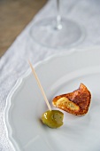 A homemade potato crisp with an olive