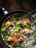 Steamed zander with green puy lentils and spinach in a pan