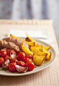 Cherry tomatoes with potatoes and sausages