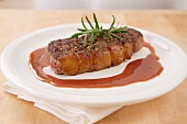 A steak with rosemary and gravy