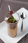 Chocolate mousse with cherries and mint leaves
