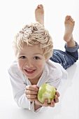 Little boy holding a partly eaten apple