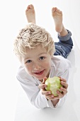 A little boy holding a half eaten apple