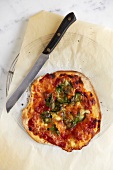 Pizza mit Tomaten, Mozzarella und Spinat auf Kuchengitter