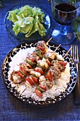Fish and vegetable kebabs on rice, side salad