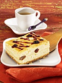 Piece of cheesecake with raisins, cup of coffee