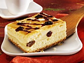 Piece of cheesecake with raisins on cake server